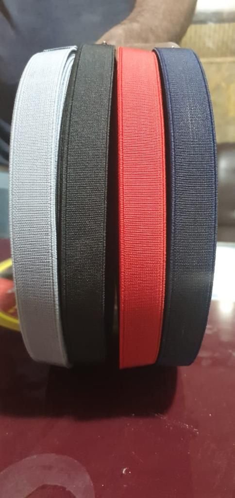Grey, black, red and navy blue elastic rolls stacked together